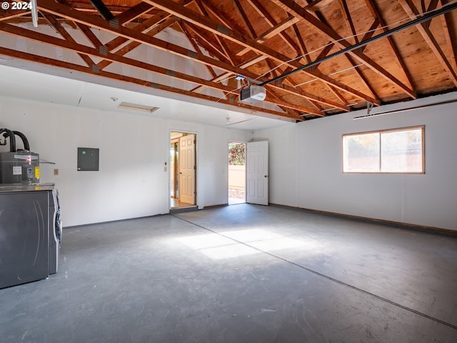 garage with electric panel, washer / dryer, a garage door opener, and water heater