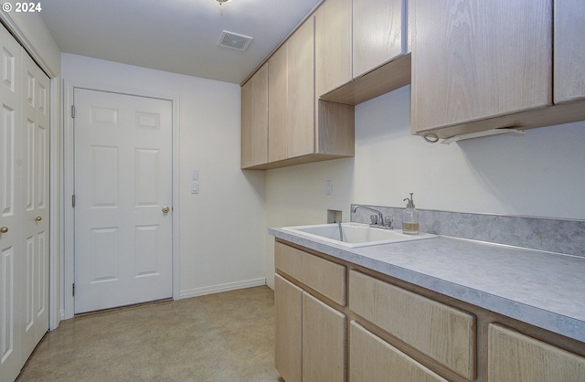 kitchen featuring visible vents, baseboards, light brown cabinetry, light countertops, and a sink