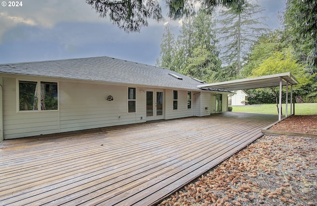 back of house featuring a lawn, french doors, a wooden deck, and roof with shingles