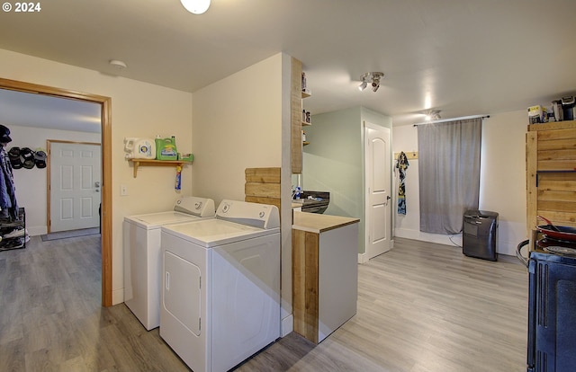 laundry room with separate washer and dryer, laundry area, and light wood finished floors