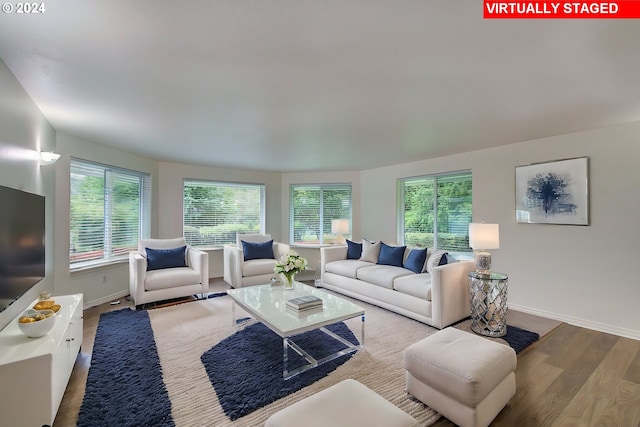 living room with plenty of natural light, wood finished floors, and baseboards