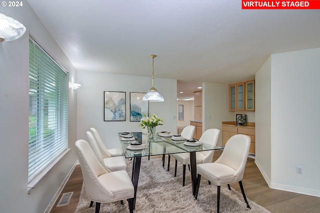 dining area with visible vents, baseboards, and wood finished floors