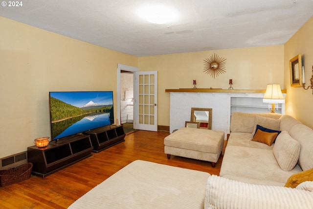 living area with baseboards, visible vents, and wood finished floors