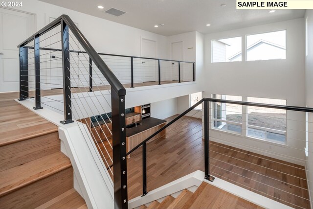 stairway featuring hardwood / wood-style floors and a healthy amount of sunlight