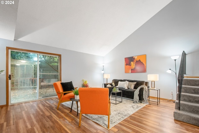 living room with high vaulted ceiling and hardwood / wood-style floors