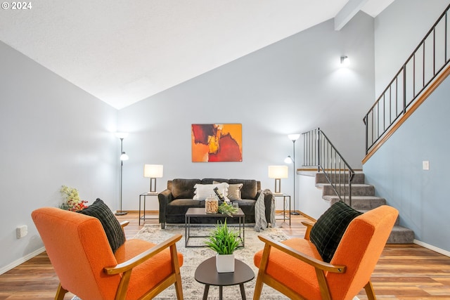 living room with high vaulted ceiling and light hardwood / wood-style flooring