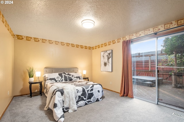 carpeted bedroom featuring access to exterior and a textured ceiling