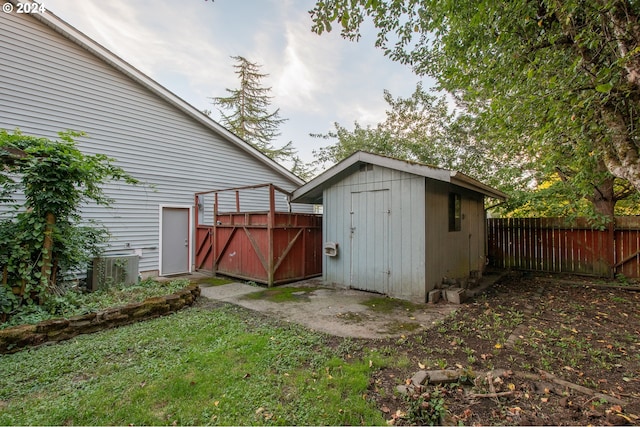 view of outbuilding with central AC unit and a lawn