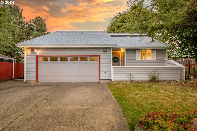 ranch-style home featuring a yard and a garage