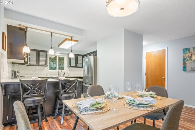 dining room with a textured ceiling, light hardwood / wood-style flooring, and sink