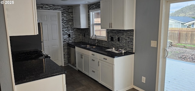 kitchen featuring sink, backsplash, white cabinets, and dishwasher