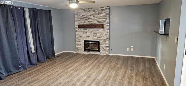 unfurnished living room featuring a fireplace, hardwood / wood-style flooring, and ceiling fan