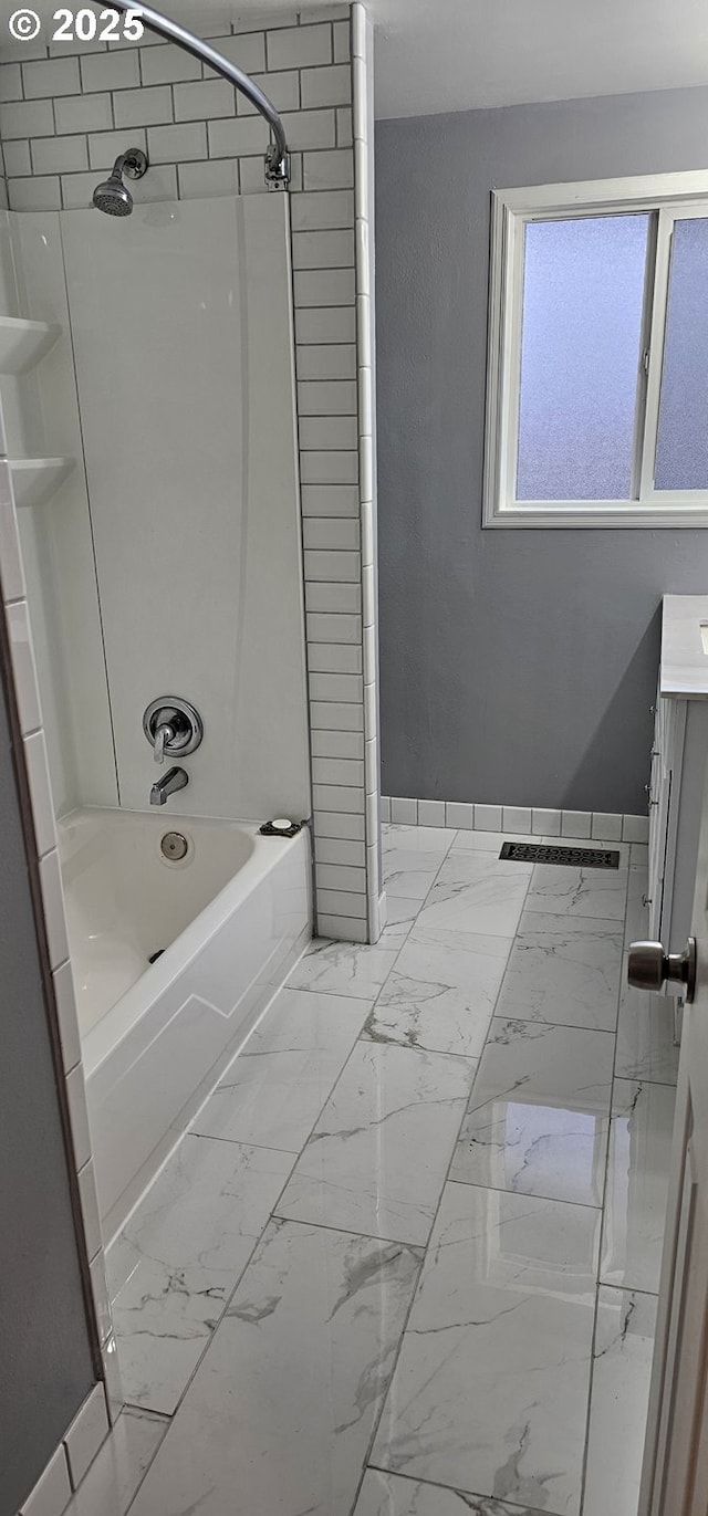 bathroom with vanity and tiled shower / bath