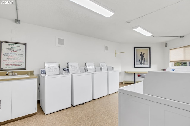 laundry area featuring washing machine and clothes dryer, sink, and baseboard heating