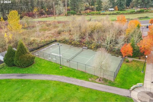 view of tennis court featuring a yard