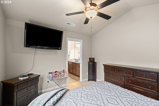 bedroom with ceiling fan, vaulted ceiling, and ensuite bath