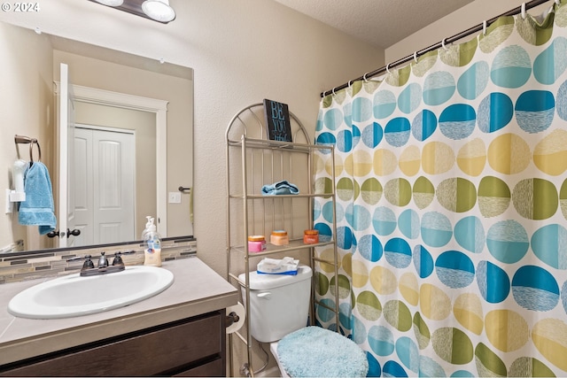 bathroom with a shower with shower curtain, backsplash, vanity, a textured ceiling, and toilet