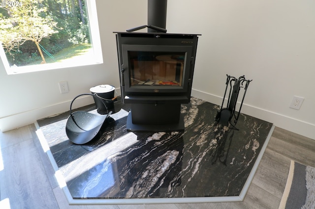 room details with a wood stove and hardwood / wood-style flooring