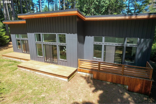 rear view of property with a deck and a lawn