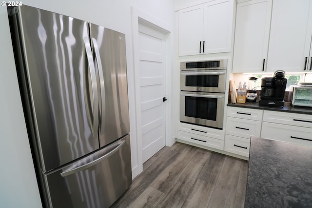 kitchen with white cabinetry, appliances with stainless steel finishes, and dark wood-type flooring