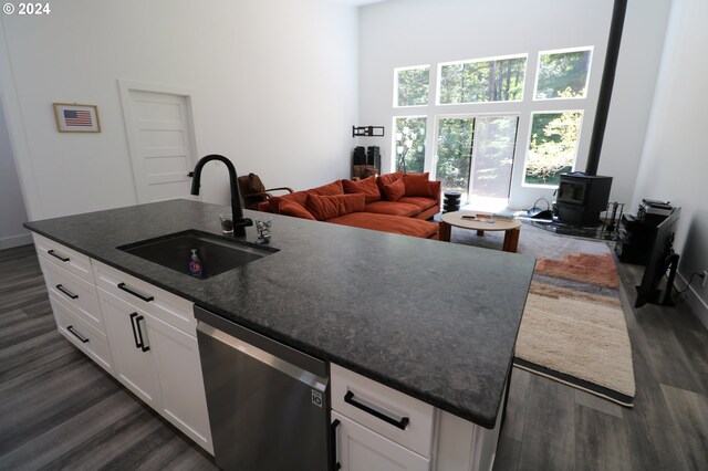 kitchen with white cabinets, dark hardwood / wood-style floors, sink, and stainless steel dishwasher