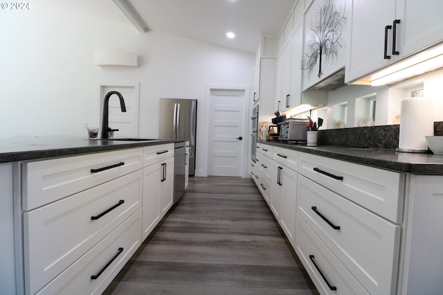 kitchen featuring lofted ceiling, sink, dark wood-type flooring, and white cabinets