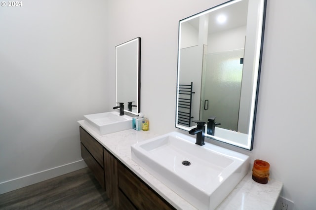 bathroom featuring hardwood / wood-style floors, walk in shower, and vanity