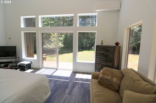 bedroom featuring a towering ceiling, dark hardwood / wood-style flooring, and multiple windows