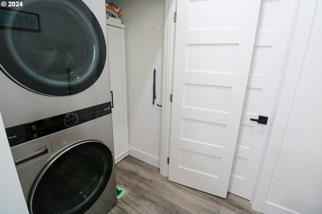 clothes washing area featuring stacked washer / drying machine and hardwood / wood-style floors