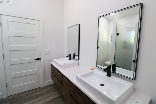 bathroom with wood-type flooring, an enclosed shower, vanity, and toilet