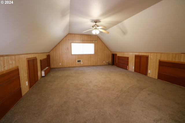 bonus room with ceiling fan, light colored carpet, wooden walls, and lofted ceiling