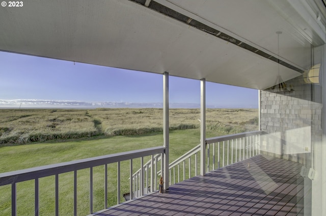 wooden deck with a yard and a rural view