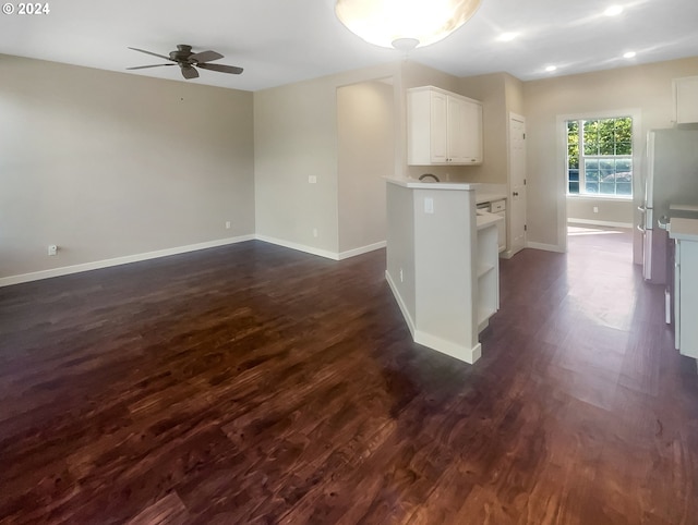 kitchen featuring ceiling fan, white fridge, dark hardwood / wood-style flooring, and white cabinetry