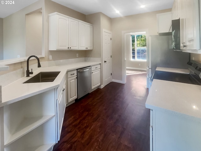 kitchen with white cabinets, appliances with stainless steel finishes, dark hardwood / wood-style floors, and sink