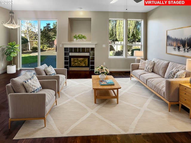 living room featuring a fireplace, hardwood / wood-style floors, and ceiling fan