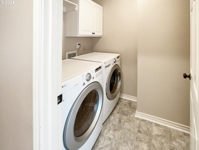 washroom with washer and clothes dryer and cabinets