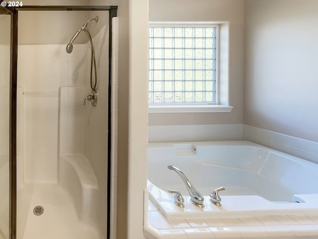 bathroom featuring separate shower and tub