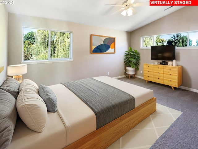 bedroom with ceiling fan, vaulted ceiling, carpet flooring, and multiple windows