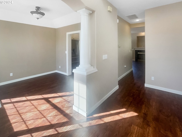 hall with ornate columns and dark hardwood / wood-style flooring