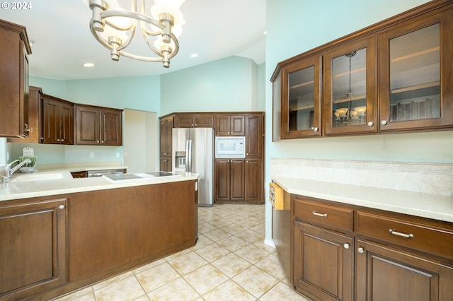 kitchen featuring light tile patterned flooring, lofted ceiling, sink, decorative light fixtures, and appliances with stainless steel finishes