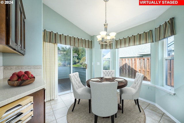 tiled dining area with lofted ceiling and a chandelier