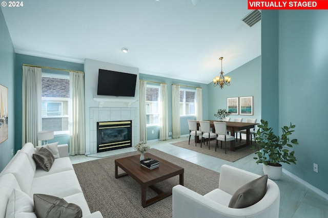 living room with lofted ceiling, a fireplace, light tile patterned floors, and a healthy amount of sunlight