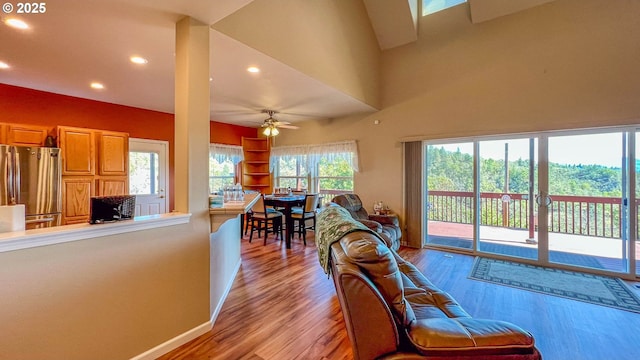 living area with a ceiling fan, recessed lighting, light wood-style flooring, and baseboards