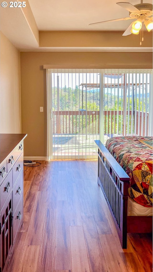 bedroom featuring baseboards, access to outside, a ceiling fan, and wood finished floors