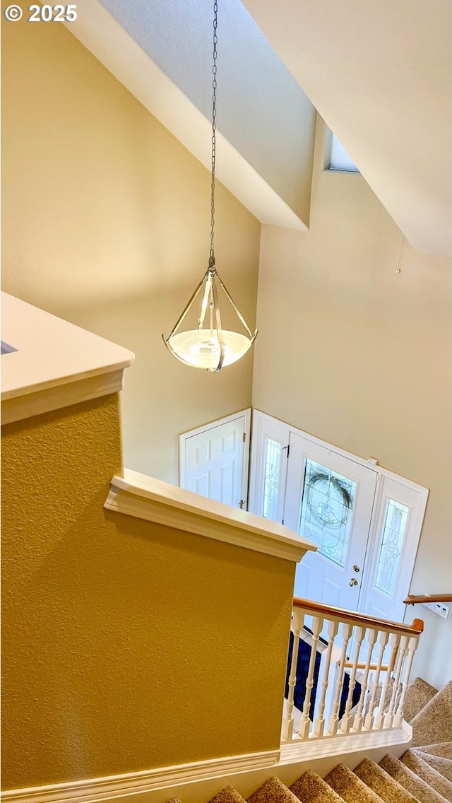 staircase featuring high vaulted ceiling