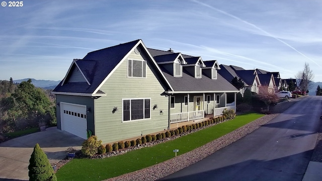 view of front of home featuring a front yard, covered porch, an attached garage, and concrete driveway