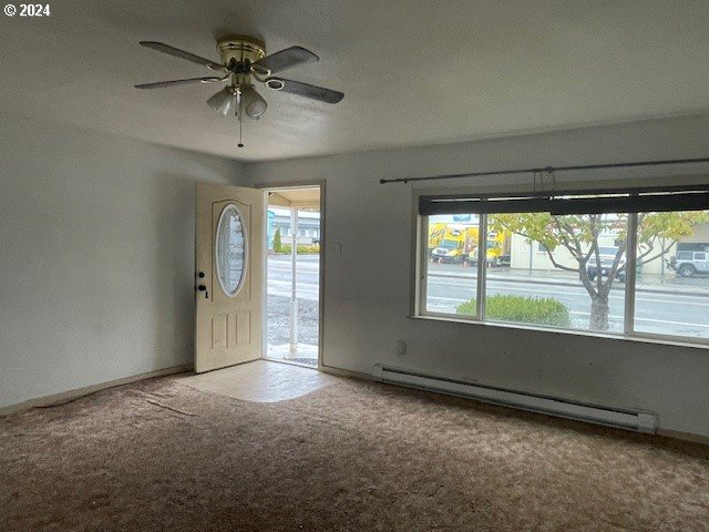170 NE Exchange Ave, Roseburg, OR 97470 - carpeted foyer featuring a baseboard heating unit, ceiling fan, and baseboards