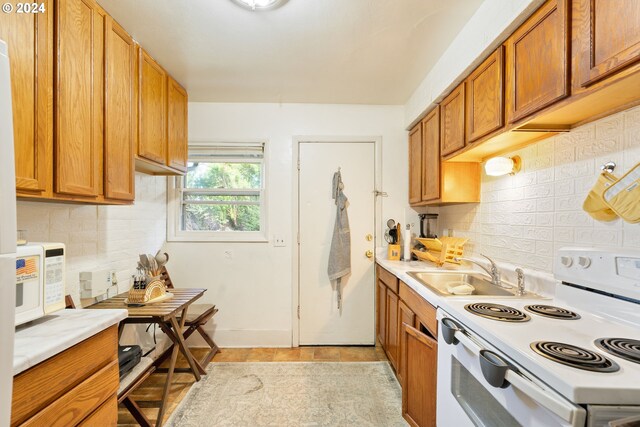 kitchen with white appliances, tasteful backsplash, and sink