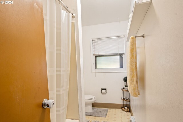 bathroom with curtained shower and toilet