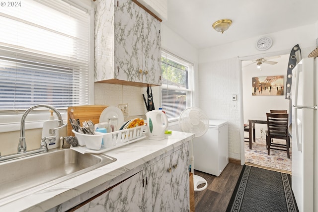 kitchen featuring dark wood-type flooring, ceiling fan, white fridge, and sink